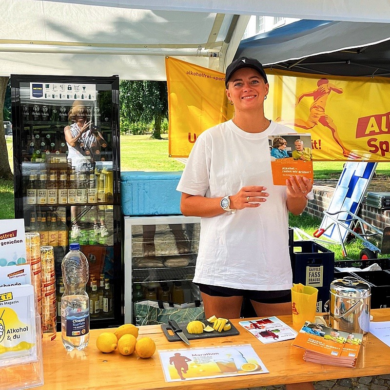 © TuS Brauweiler Junge Dame hinter dem einladend gestalteten  „Alkoholfrei Sport genießen“-Infostand.